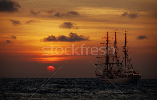 Old sailing ship in the sea at sunset Stock photo © pzaxe