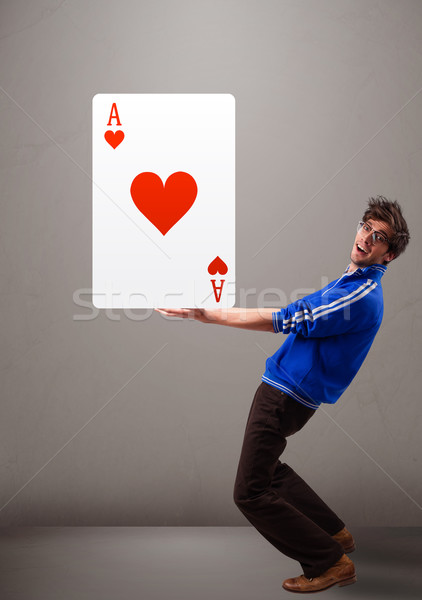 Young man holding a red heart ace Stock photo © ra2studio