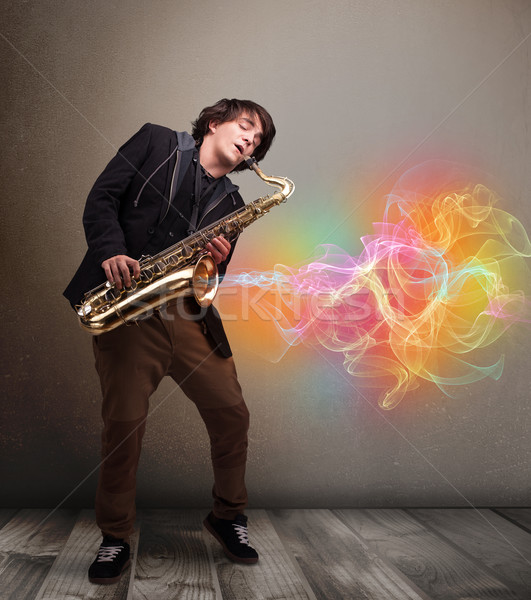 Attractive musician playing on saxophone with colorful abstract  Stock photo © ra2studio