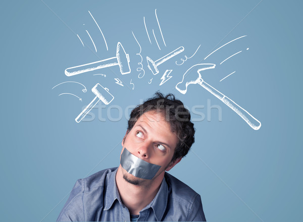 Stock photo: Young man with glued mouth and beating hammer marks