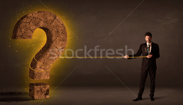 Business man pulling a big solid question mark stone Stock photo © ra2studio