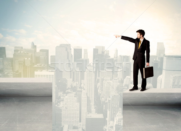 Businessman standing on the edge of rooftop Stock photo © ra2studio