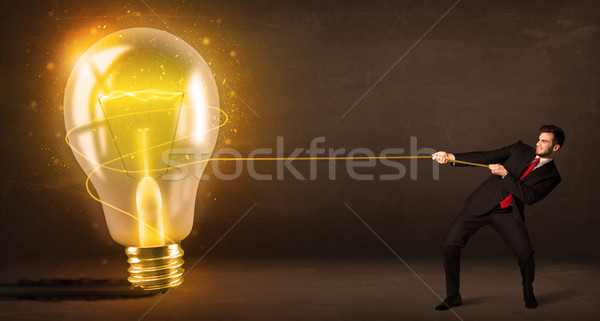 üzletember húz nagy fényes izzó villanykörte Stock fotó © ra2studio
