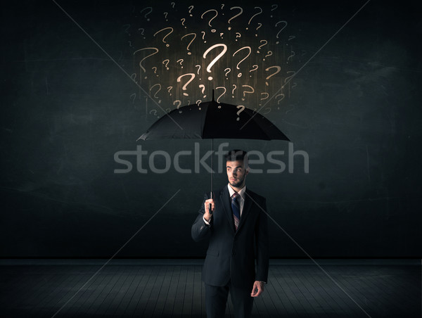 Businessman with umbrella and a lot of drawn question marks Stock photo © ra2studio