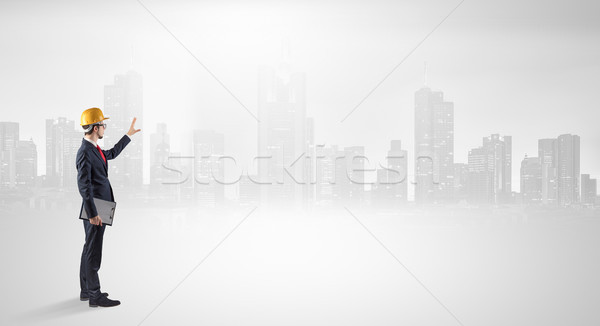 Architect standing and  looking at a big city panorama Stock photo © ra2studio