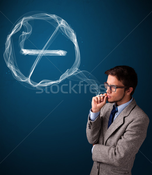 Young man smoking unhealthy cigarette with no smoking sign Stock photo © ra2studio