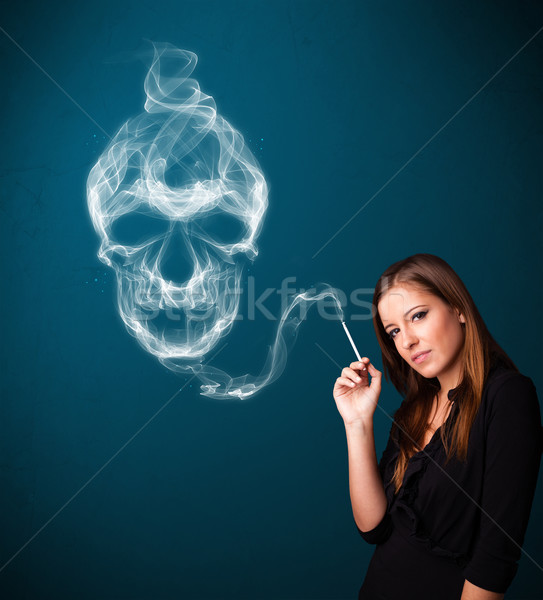 Young woman smoking dangerous cigarette with toxic skull smoke  Stock photo © ra2studio