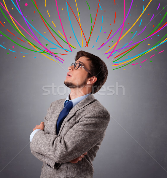 Young man thinking wiht colorful abstract lines overhead Stock photo © ra2studio