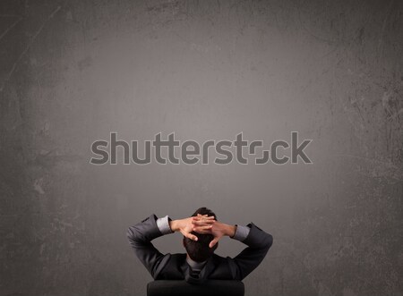 Businessman sitting in front of a wall with copy space Stock photo © ra2studio