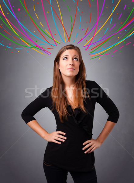 Young girl thinking with colorful abstract lines overhead Stock photo © ra2studio