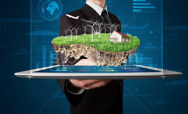 Young businessman presenting a perfect ecology land with a house and windmills Stock photo © ra2studio