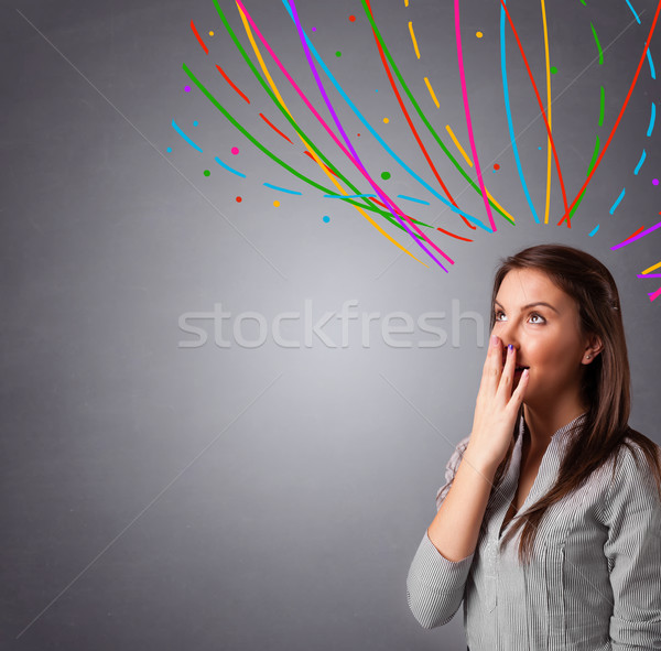 Young girl thinking with colorful abstract lines overhead Stock photo © ra2studio