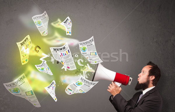 Guy yelling into loudspeaker and newspapers fly out Stock photo © ra2studio