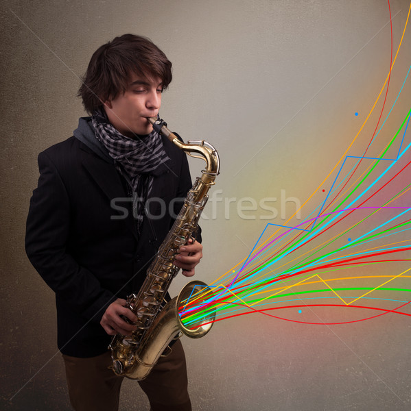 Attractive musician playing on saxophone while colorful abstract Stock photo © ra2studio