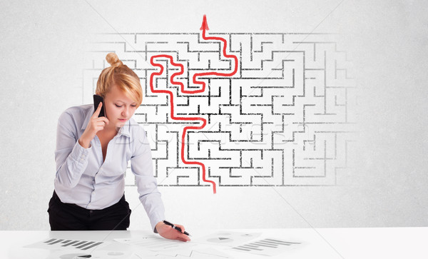 Stock photo: Business woman at desk with labyrinth and arrow