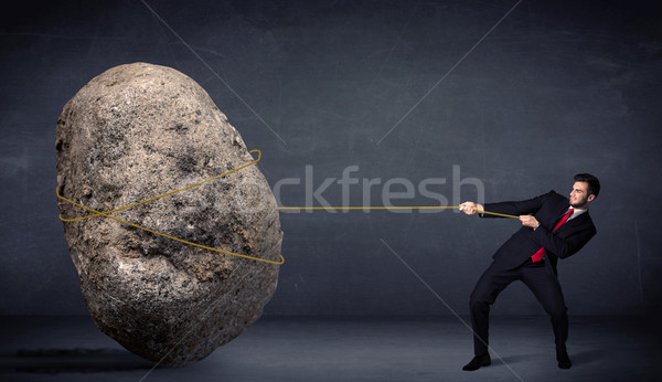 Businessman pulling huge rock with a rope  Stock photo © ra2studio