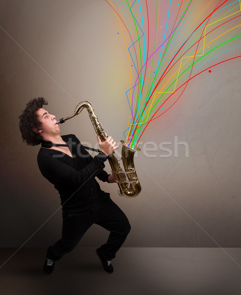 Attractive musician playing on saxophone while colorful abstract Stock photo © ra2studio