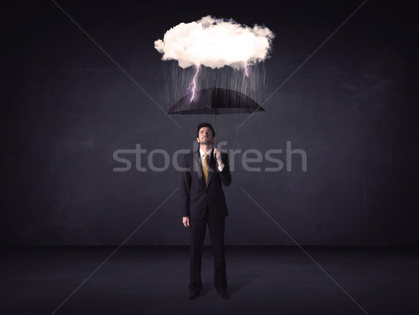 Businessman standing with umbrella and little storm cloud Stock photo © ra2studio