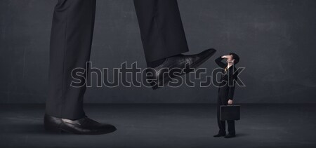Huge leg stepping on a tiny businnessman concept Stock photo © ra2studio