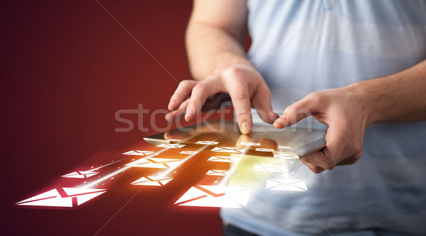 Stock photo: Hand holding tablet and sending email icons