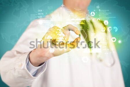 Doctor holding a pill between fingers Stock photo © ra2studio