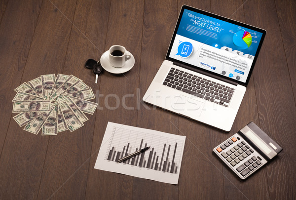 Laptop on office desk with business website on screen Stock photo © ra2studio