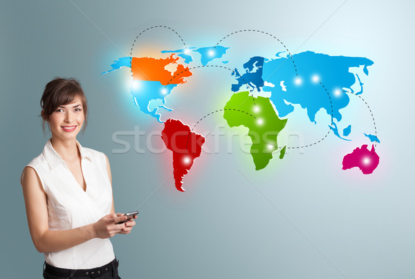 Young woman holding a phone and presenting colorful world map Stock photo © ra2studio