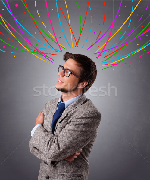 Young man thinking wiht colorful abstract lines overhead Stock photo © ra2studio