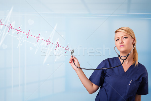 Pretty medical doktor listening to red pulse and heart rates Stock photo © ra2studio