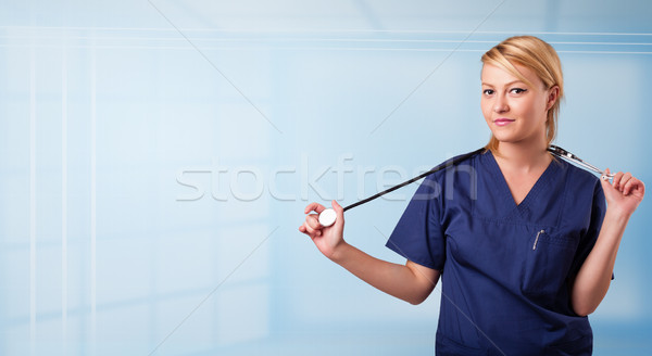 Pretty young nurse in hospital listening to empty copy space with sthetoscope Stock photo © ra2studio