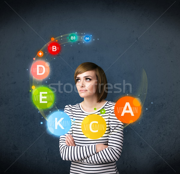 Young woman thinking with vitamins circulation around her head Stock photo © ra2studio
