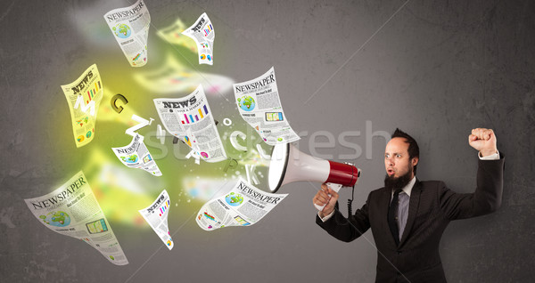 Guy yelling into loudspeaker and newspapers fly out Stock photo © ra2studio