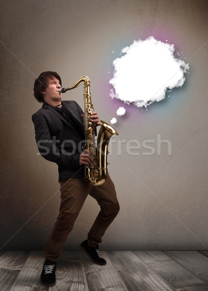 Young man playing on saxophone with copy space in white cloud Stock photo © ra2studio