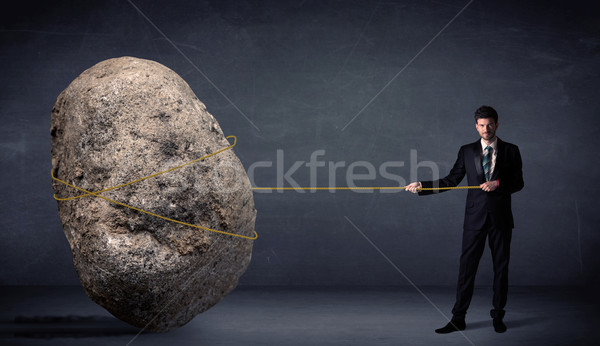 Businessman pulling huge rock with a rope  Stock photo © ra2studio