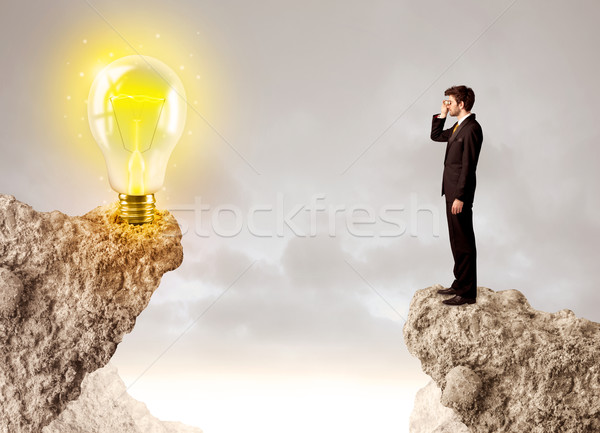 Businessman on rock mountain with idea bulb Stock photo © ra2studio