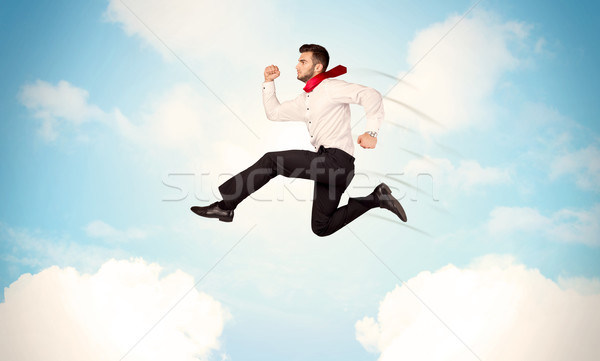 Business person jumping over clouds in the sky Stock photo © ra2studio