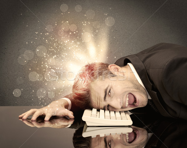Angry businessman with lights and keyboard Stock photo © ra2studio
