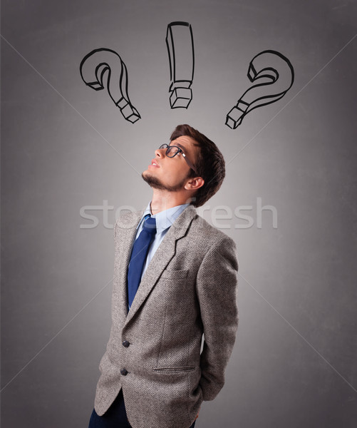 Young man thinking with question marks overhead Stock photo © ra2studio