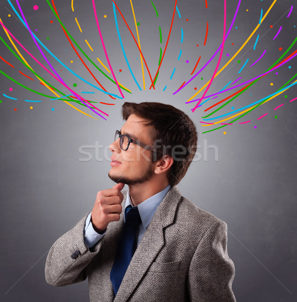 Young man thinking wiht colorful abstract lines overhead Stock photo © ra2studio