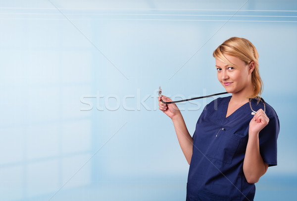 Pretty young nurse in hospital listening to empty copy space with sthetoscope Stock photo © ra2studio