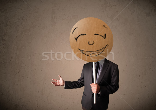 Businessman holding a smiley face board Stock photo © ra2studio