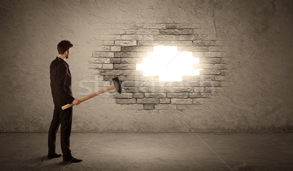 Business man hitting brick wall with hammer and opening a hole Stock photo © ra2studio