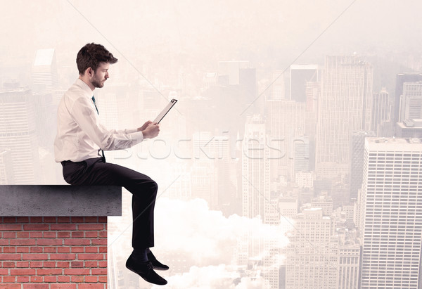 Office worker sitting on rooftop in city Stock photo © ra2studio