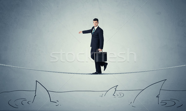 Businessman walking on rope above sharks Stock photo © ra2studio