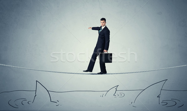 Businessman walking on rope above sharks Stock photo © ra2studio