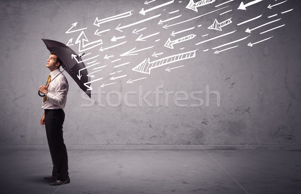 Business man standing with umbrella and drawn arrows hitting him Stock photo © ra2studio