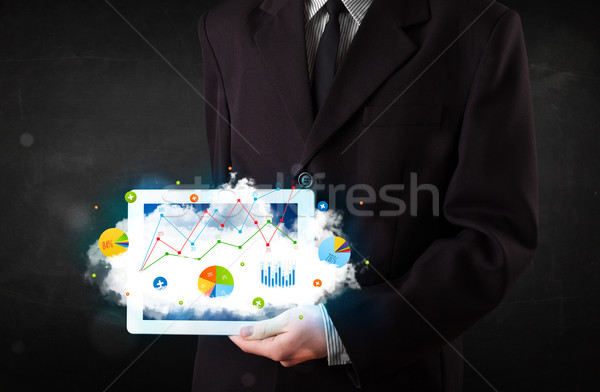 Stock photo: Person holding a touchpad with cloud technology and charts