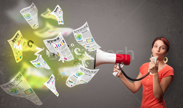 Girl yelling into loudspeaker and newspapers fly out Stock photo © ra2studio