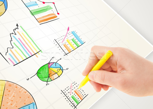 Business person drawing colorful graphs and icons on paper Stock photo © ra2studio