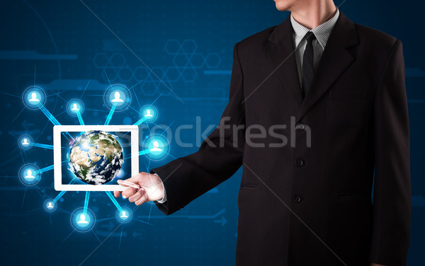Stock photo: Businessman presenting 3d earth globe in tablet